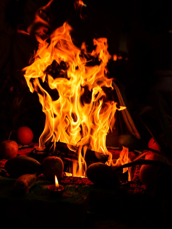 A dramatic depiction of a ritual fire at night with vivid orange flames.